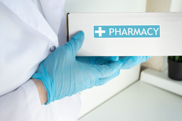 a medical courier delivers a box labeled pharmacy